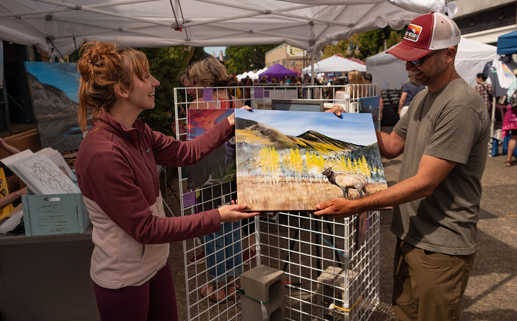 An artist shares her wares at the Blackberry Arts Festival in Coos Bay.