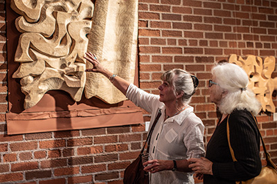 two women admiring a large sculptural art piece at the Coos Art Museum