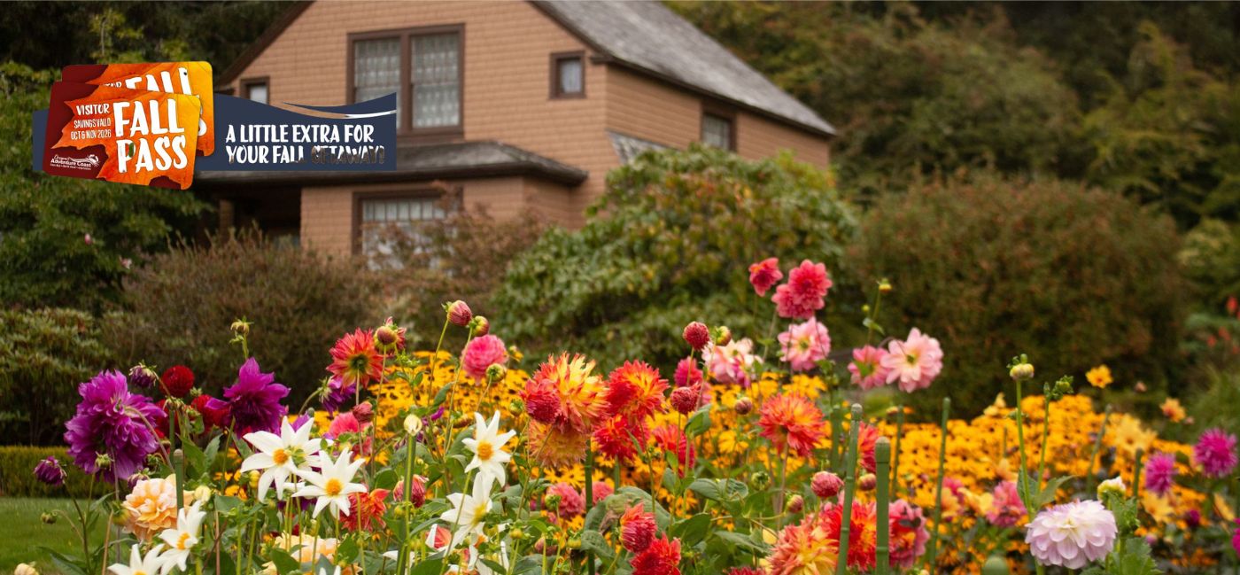 Colorful dahlia garden in bloom in front of a historic house, with Fall Pass promotional badge