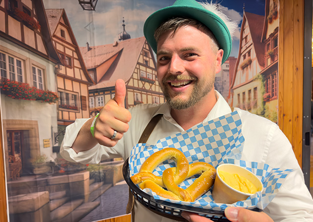 Man in German garb holding pretzel